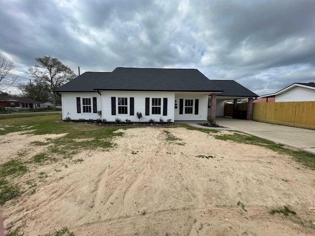 back of house with a carport, driveway, and fence