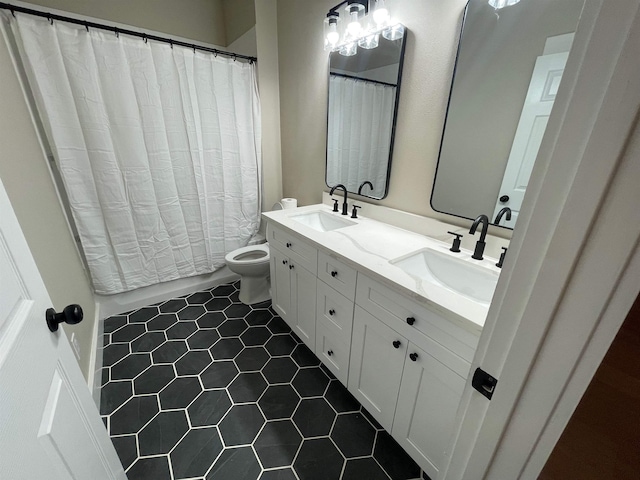 bathroom with double vanity, toilet, tile patterned floors, and a sink