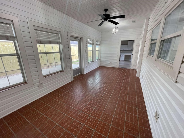 unfurnished sunroom with ceiling fan