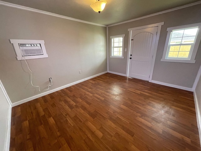 entryway with an AC wall unit, wood finished floors, baseboards, and ornamental molding