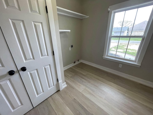 clothes washing area with light wood finished floors, laundry area, hookup for an electric dryer, and baseboards