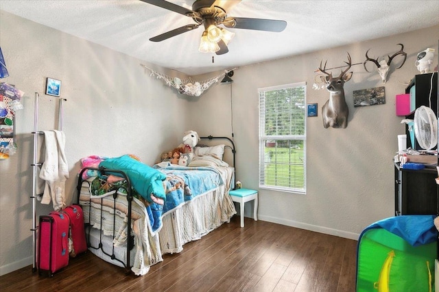 bedroom with ceiling fan, dark hardwood / wood-style flooring, and a textured ceiling