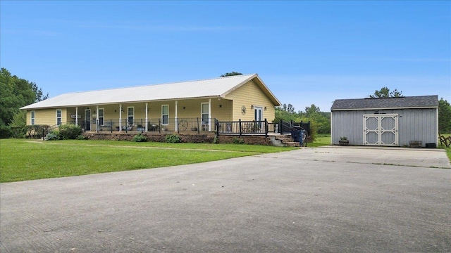 ranch-style home with covered porch, a front yard, and a storage shed