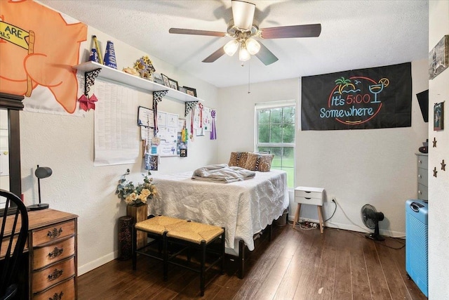 bedroom with a textured ceiling, dark hardwood / wood-style floors, and ceiling fan