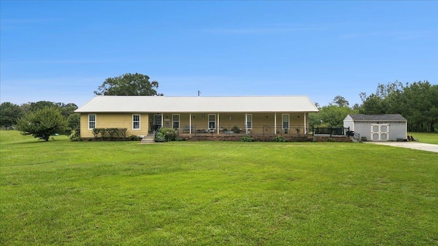 ranch-style home featuring covered porch, a storage shed, and a front yard