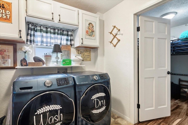 clothes washing area with hardwood / wood-style floors, cabinets, a textured ceiling, and washing machine and clothes dryer