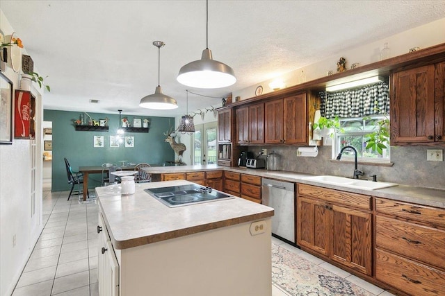 kitchen with sink, stainless steel dishwasher, pendant lighting, electric cooktop, and a kitchen island