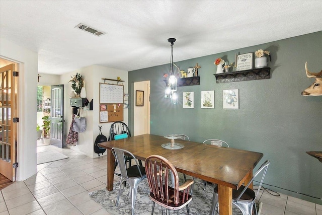 tiled dining room featuring a textured ceiling