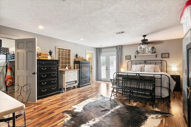 bedroom featuring french doors, hardwood / wood-style floors, a textured ceiling, and ceiling fan