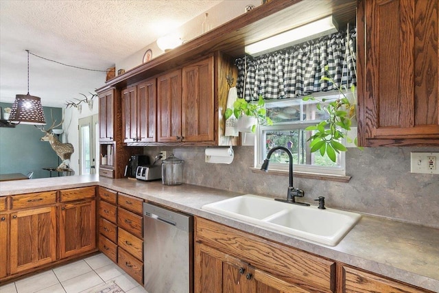 kitchen with pendant lighting, sink, stainless steel dishwasher, a textured ceiling, and tasteful backsplash