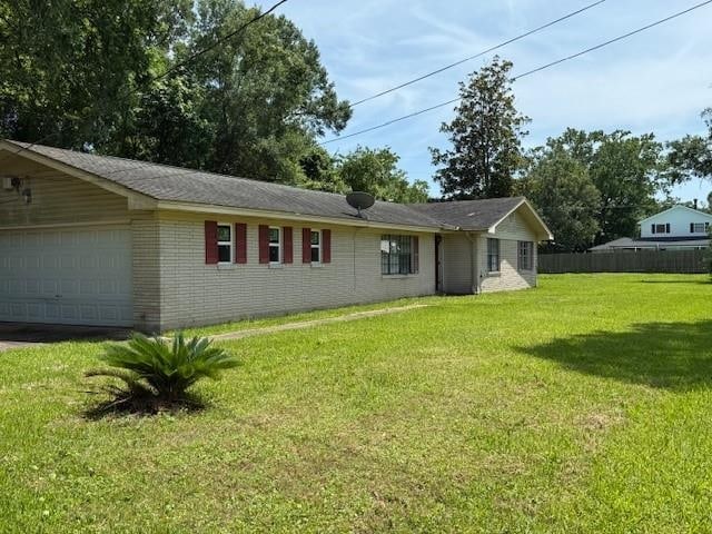 880 Norbert St, Bridge City, TX 77611 - rear view of house with brick siding and an attached garage