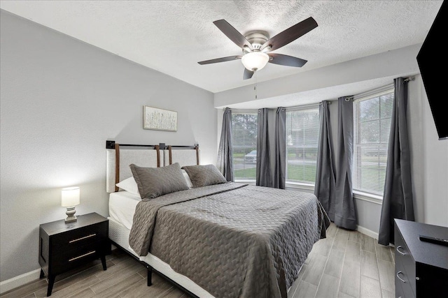 11503 Davidson Rd, Beaumont, TX 77705 - bedroom with wood finish floors, multiple windows, a textured ceiling, and ceiling fan