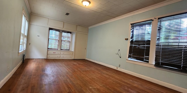 spare room with wood-type flooring and ornamental molding