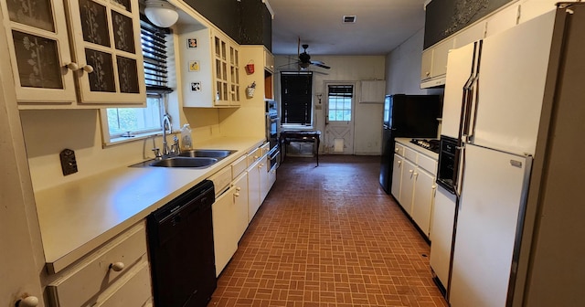 kitchen featuring ceiling fan, sink, white cabinets, black dishwasher, and white fridge