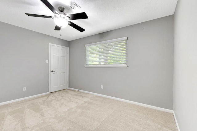 spare room with light carpet and ceiling fan