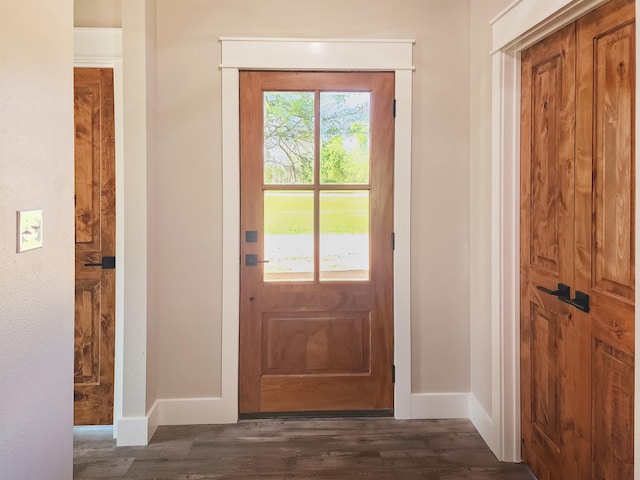 doorway with dark wood-style flooring and baseboards