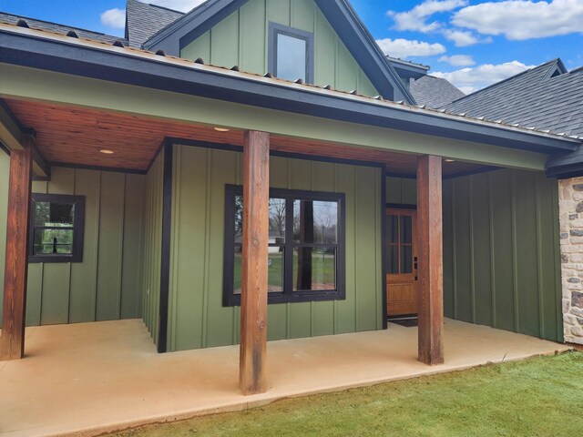 back of property with board and batten siding and a shingled roof