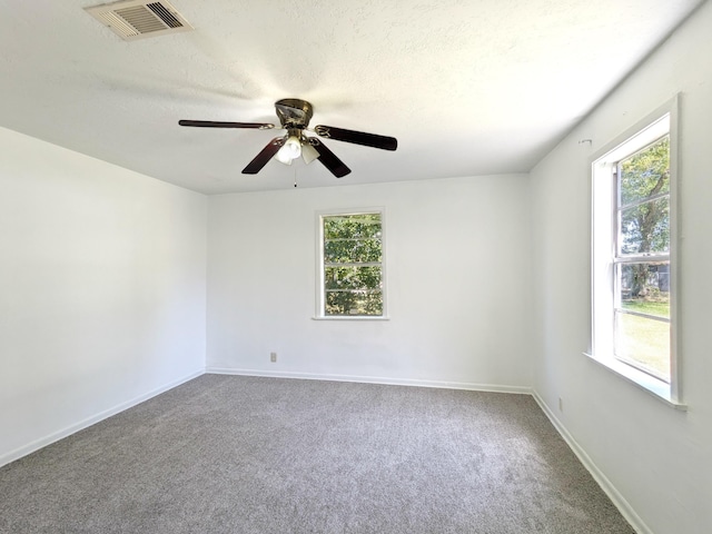 carpeted spare room with ceiling fan and a textured ceiling