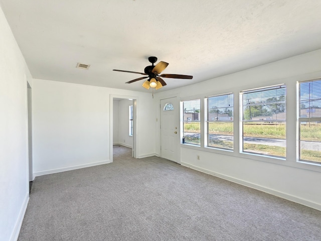 carpeted empty room with a textured ceiling and ceiling fan