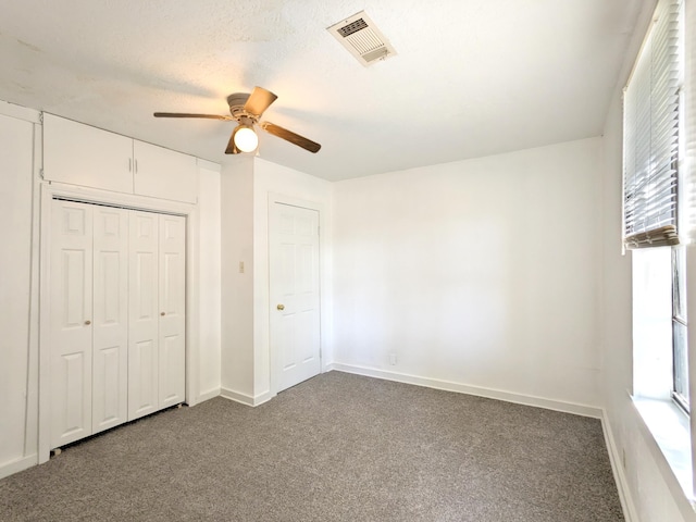 unfurnished bedroom featuring ceiling fan, a closet, carpet, and a textured ceiling