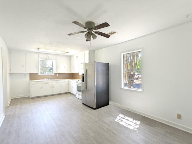 kitchen with sink, white cabinetry, stainless steel fridge with ice dispenser, light wood-type flooring, and white gas range oven