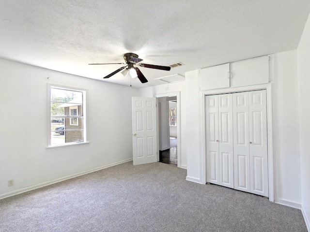 unfurnished bedroom with light colored carpet, a closet, and a textured ceiling