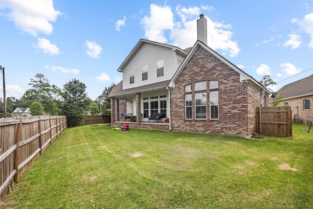 220 Idylwild Dr, Sour Lake, TX 77659 - back of house featuring brick siding, a fenced backyard, a lawn, and a patio
