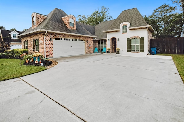 french provincial home with a garage and a front lawn