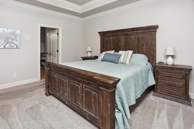 bedroom with light carpet, ensuite bathroom, a tray ceiling, and crown molding