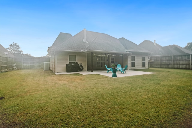 back of house featuring a lawn and a patio