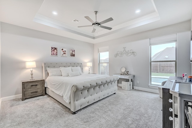 bedroom featuring ceiling fan, carpet flooring, and a tray ceiling