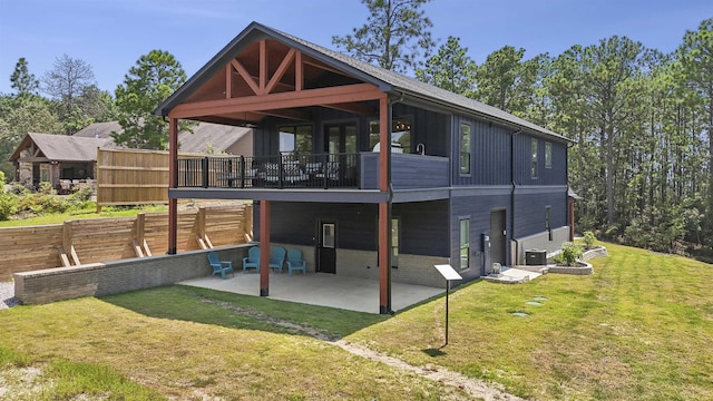 rear view of house featuring a patio, a balcony, central AC, and a lawn