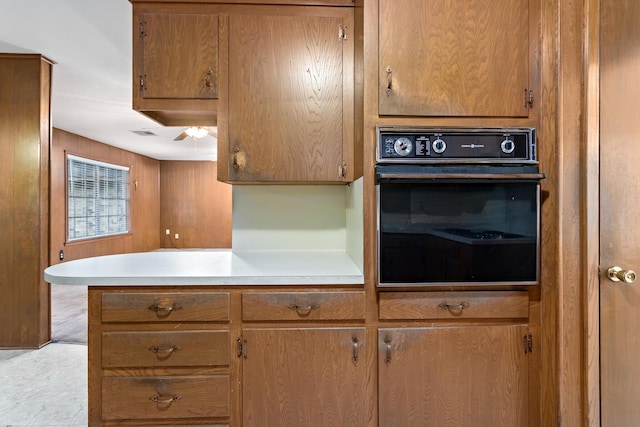 6355 Arrowhead Dr, Beaumont, TX 77707 - kitchen featuring black oven, brown cabinetry, and light countertops
