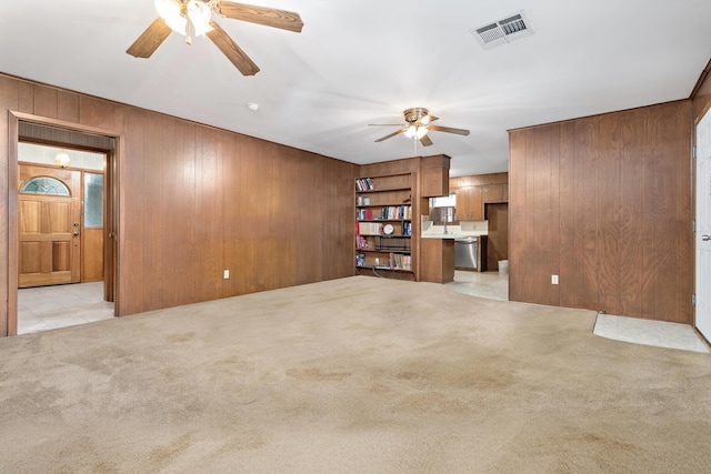 6355 Arrowhead Dr, Beaumont, TX 77707 - unfurnished living room with ceiling fan, wooden walls, light carpet, and visible vents