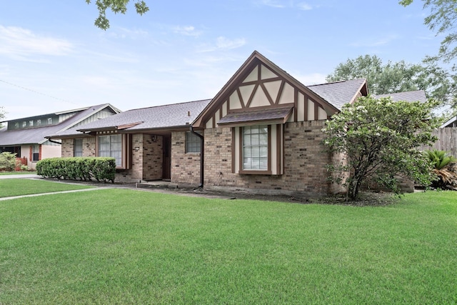 6355 Arrowhead Dr, Beaumont, TX 77707 - tudor house with a front lawn, brick siding, and roof with shingles