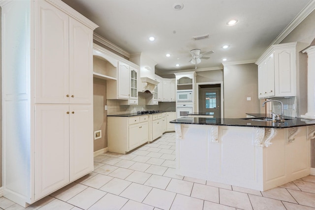 kitchen featuring ceiling fan, kitchen peninsula, crown molding, white appliances, and white cabinets