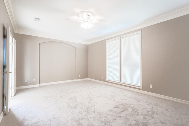 carpeted spare room with ceiling fan and crown molding