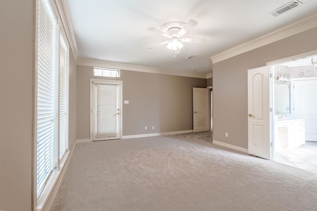 spare room with light carpet, a healthy amount of sunlight, ceiling fan, and crown molding