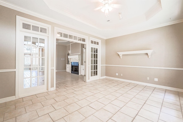 spare room with light tile patterned floors, a raised ceiling, ceiling fan, and crown molding