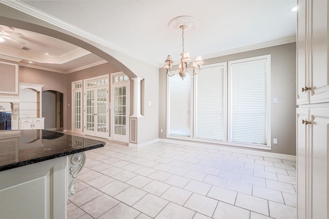 unfurnished dining area featuring a raised ceiling, crown molding, light tile patterned flooring, and a chandelier