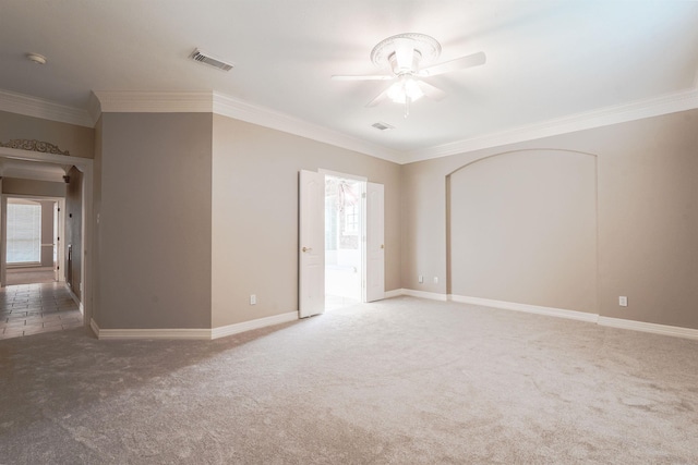 carpeted spare room featuring ceiling fan, a healthy amount of sunlight, and ornamental molding