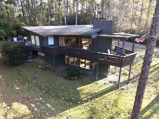 back of house with a wooden deck and a yard