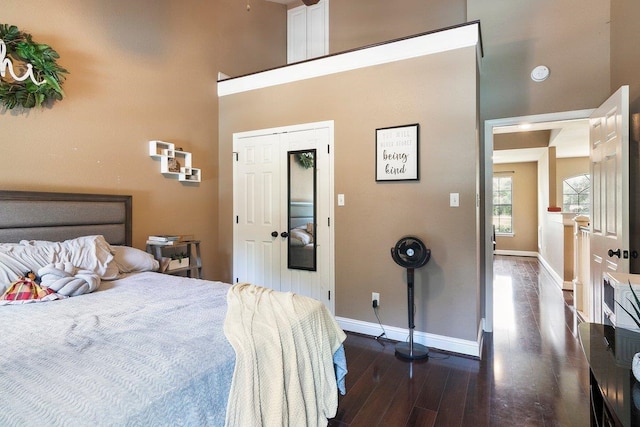 bedroom featuring a high ceiling and dark wood-type flooring