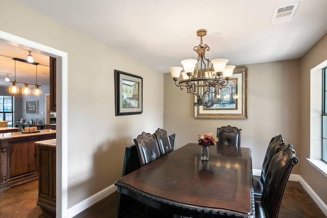 dining room featuring dark hardwood / wood-style flooring and a notable chandelier