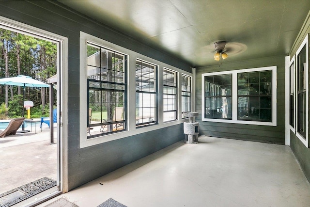 unfurnished sunroom featuring ceiling fan