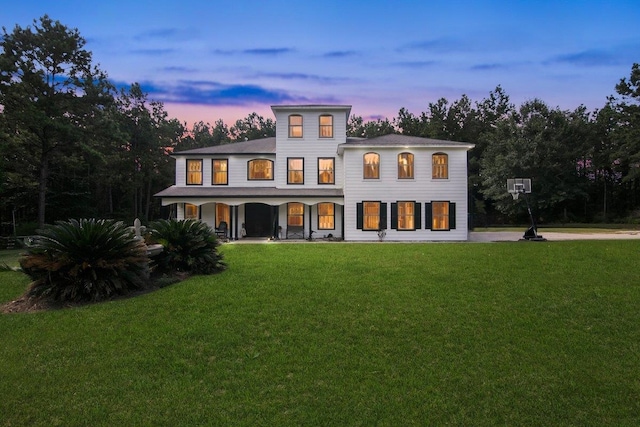 view of front of property with a porch and a yard