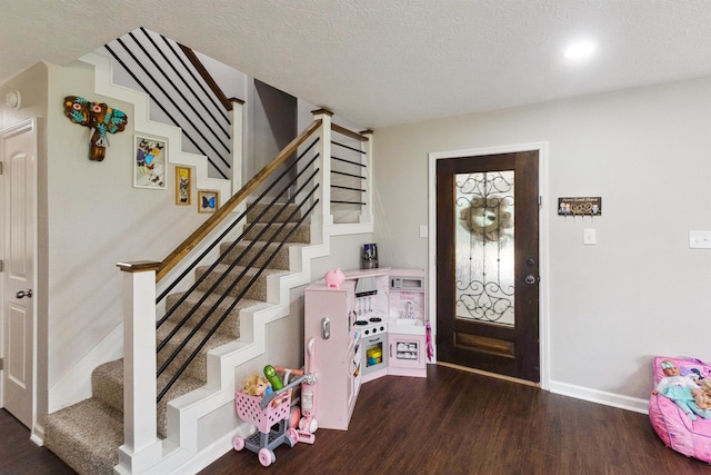 foyer featuring dark hardwood / wood-style floors and a textured ceiling