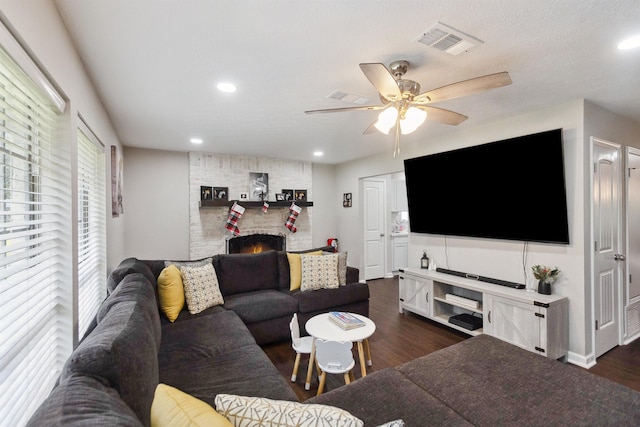 living room with dark hardwood / wood-style floors, ceiling fan, and a fireplace