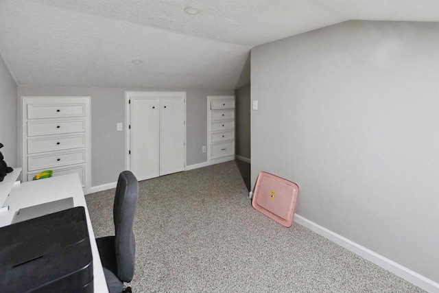 unfurnished office with carpet flooring, a textured ceiling, and vaulted ceiling