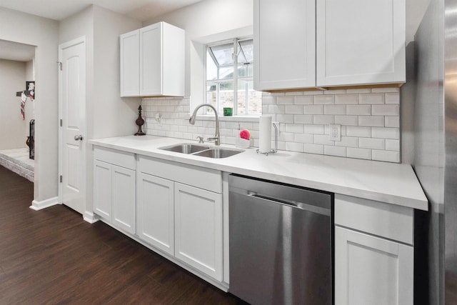 kitchen with white cabinetry, sink, light stone countertops, dark hardwood / wood-style floors, and appliances with stainless steel finishes